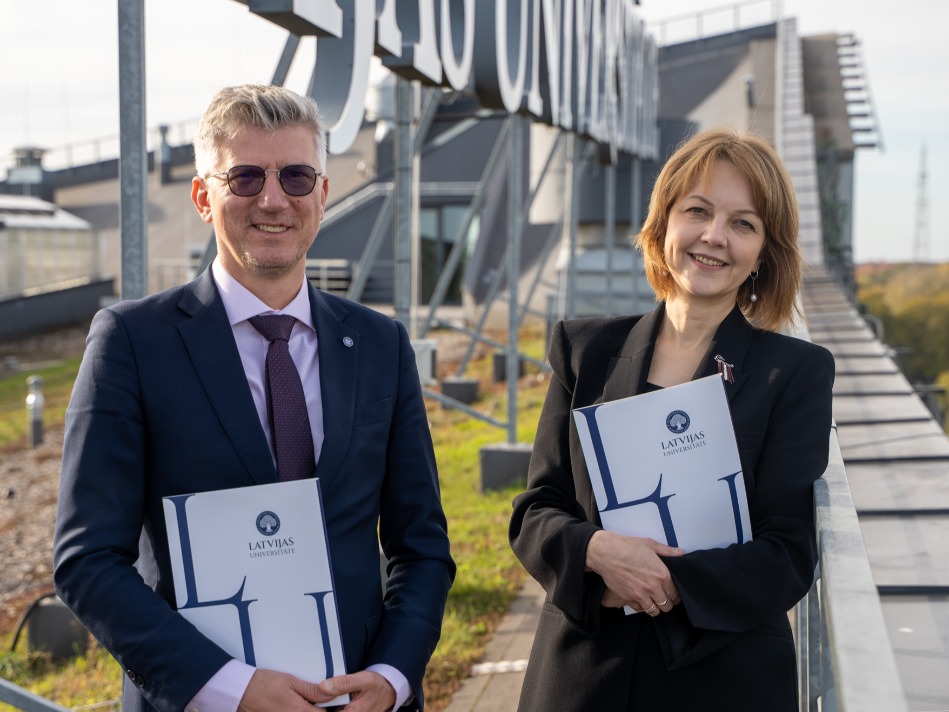 Uz Latvijas Universitātes Dabas mājas jumta Enno Ence un Ieva Viļuma tur Latvijas Universitātes dokumentu mapes.
